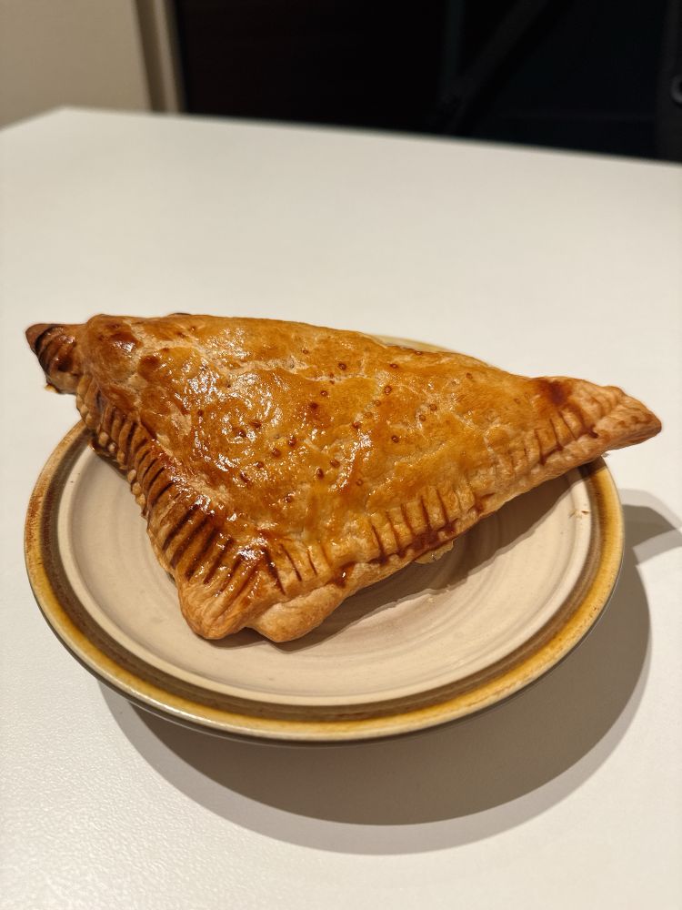 皿に載った三角の形のアップルパイ