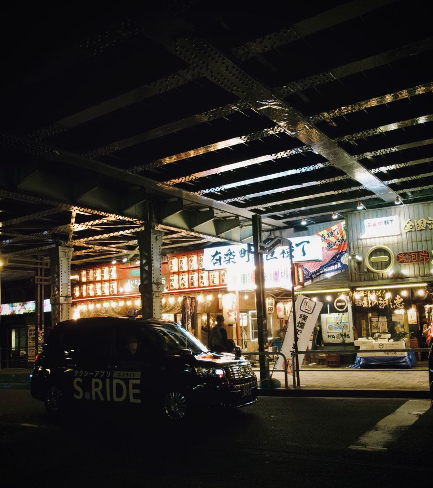 高架下の居酒屋街 手前にタクシーが止まっている