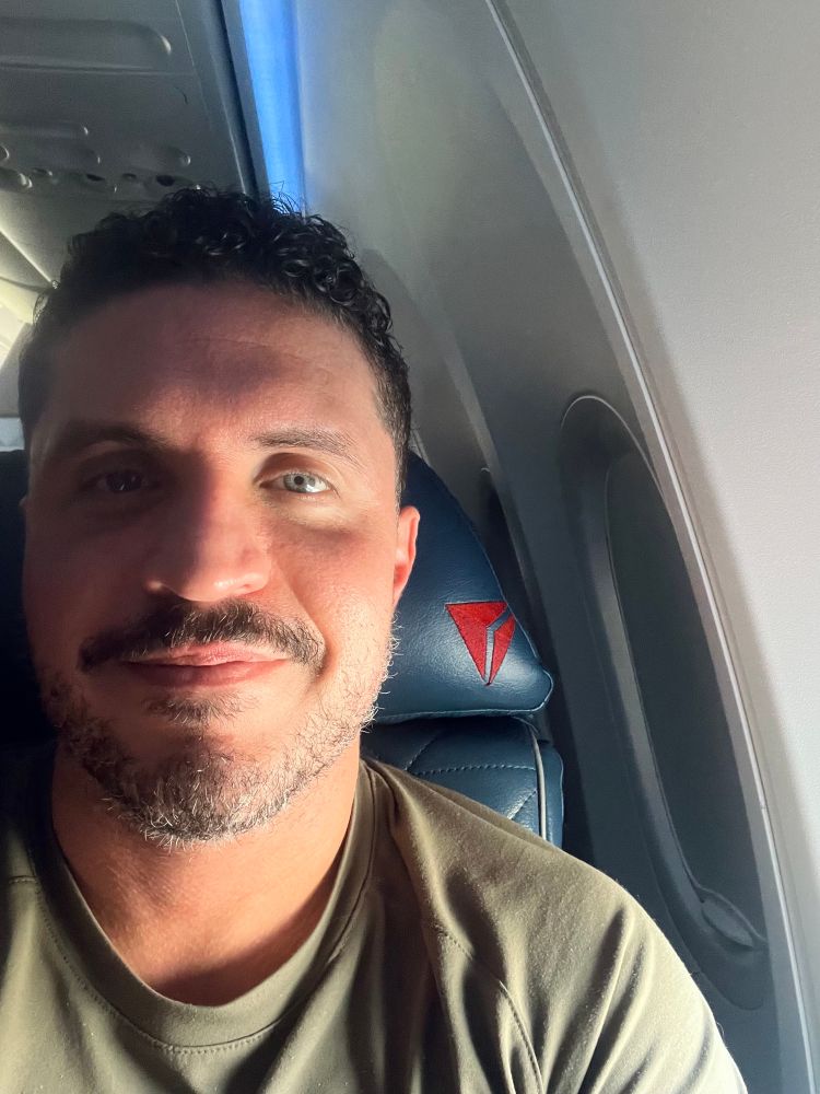 meee sitting in my seat on a Delta flight with the lighting shining on my from the window