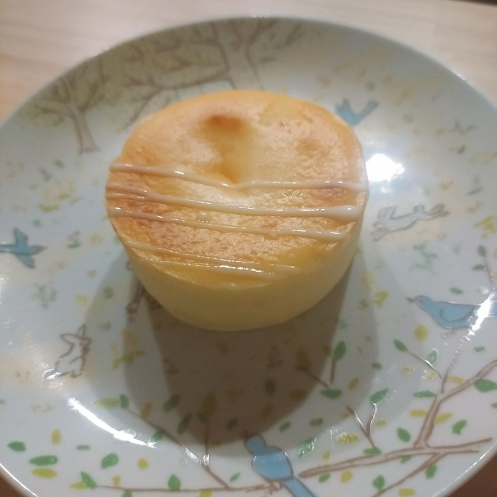 お皿にのった丸いチーズケーキがひとつ