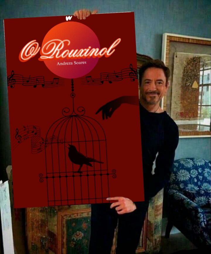 Imagem do ator do Robert Downey Jr segurando uma capa gigante do livro "O Rouxinol" 
É uma capa vermelha com a silhueta de um pássaro na gaiola saindo notas musicais da boca dele atrás tem a silhueta de uma mão e acima o título O Rouxinol