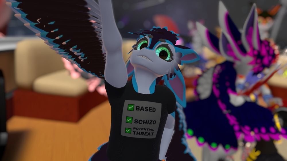 An avali in the black t-shirt with the label "based, schizo, potential threat" with a bunch of other avali in the blurry background
