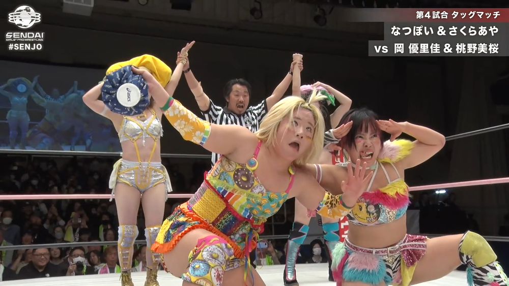 Natsupoi & Aya Sakura wearing the strawberry & banana hats while having the hands raised by the ref. Unfortunately for them, Yurika Oka and Mio Momono have stolen the spotlight and pose with funny faces in front of them. Yurika's ice bag is covering Natsuppi's face perfectly. lmao