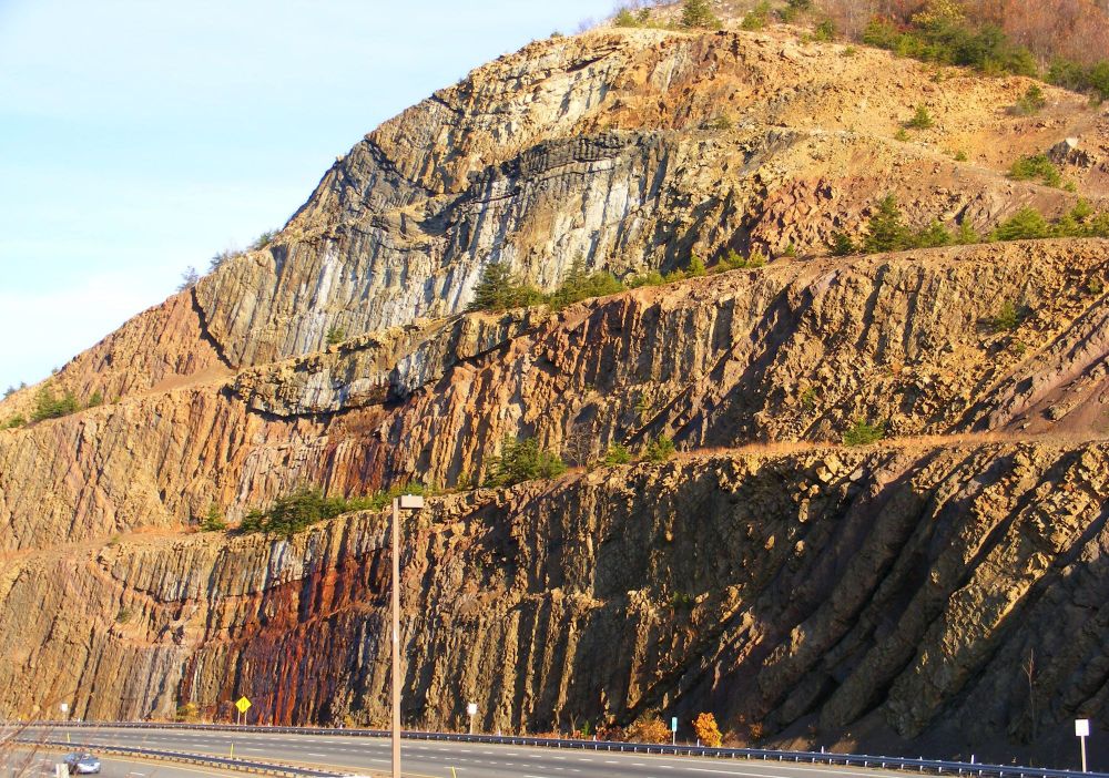 The Sideling Hill roadcut in western Maryland is a textbook example of a syncline. Here the sedimentary rock bedding has been folded into a U-shape by compressive tectonic forces. The corresponding A-shaped anticlines on either side have been eroded away. I-68 west of Hancock Maryland, 02 Nov 2010.