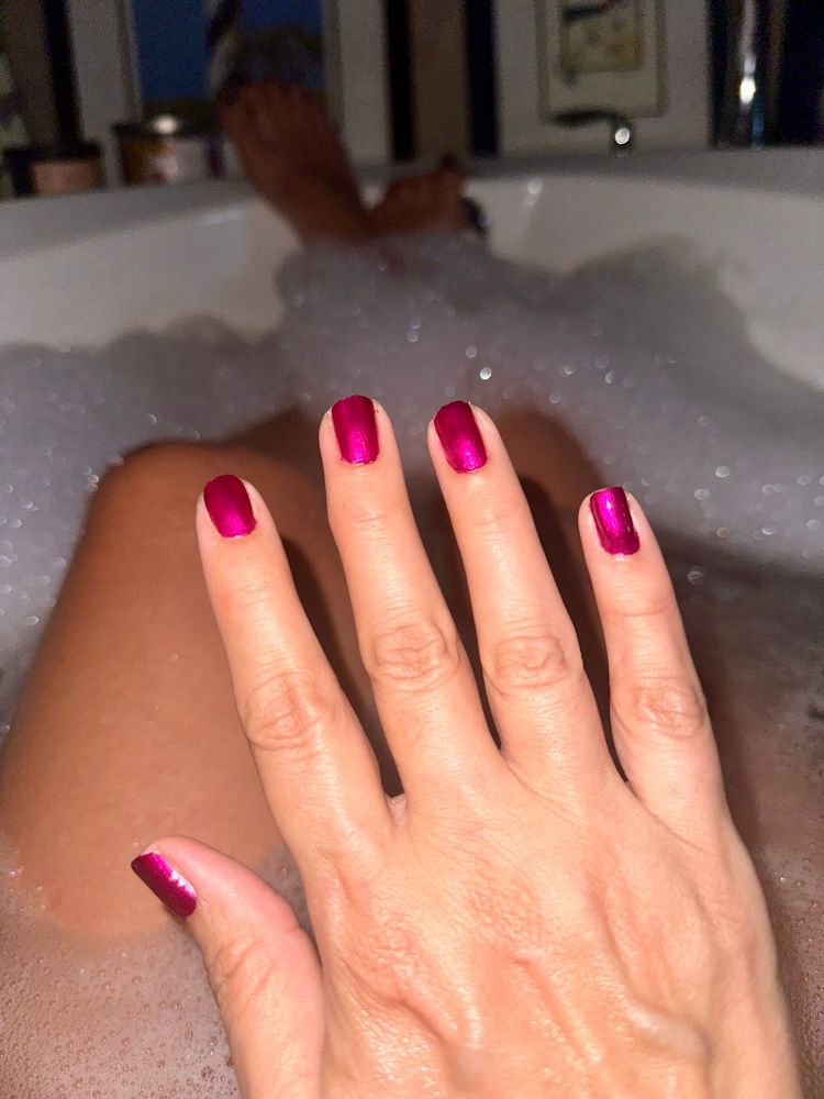 Manicured hand covering thighs in the bath