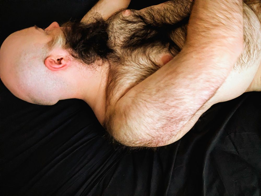 Photo of me naked in bed from the torso up, looking away from the camera