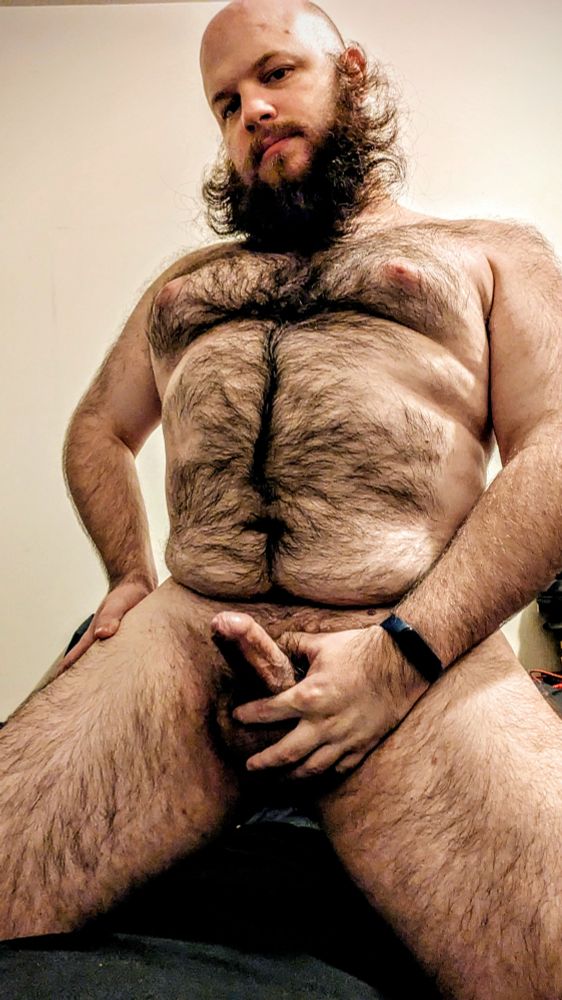 Selfie of me naked kneeling on a bed holding my hard dick in my hand