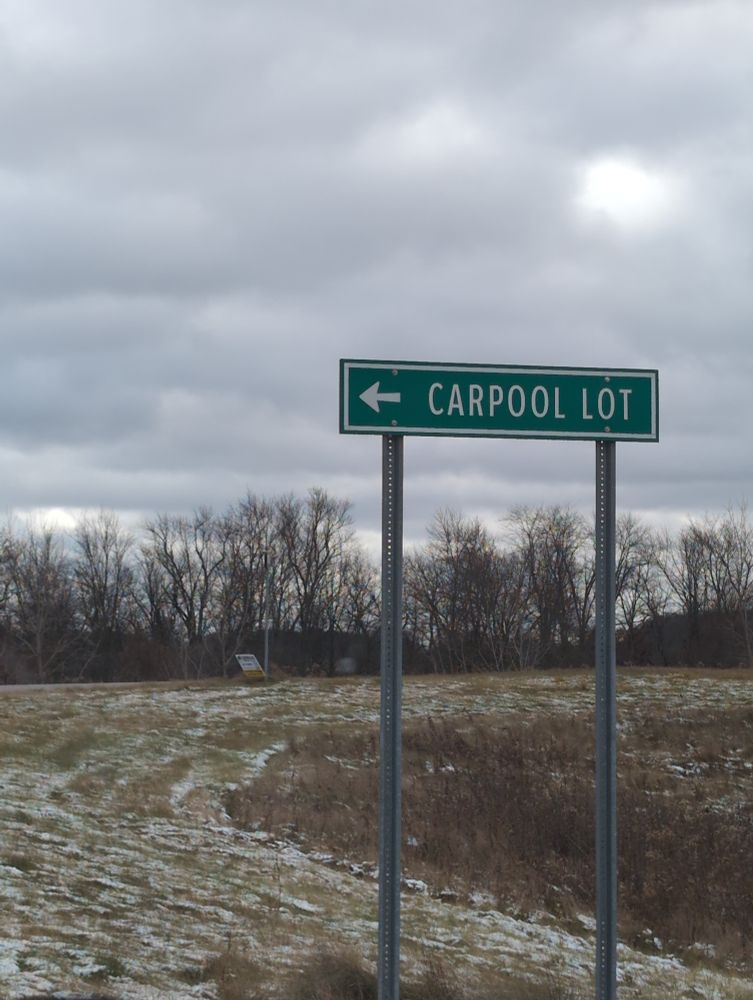 Freezing landscape with a carpool lot sign in front of deciduous trees