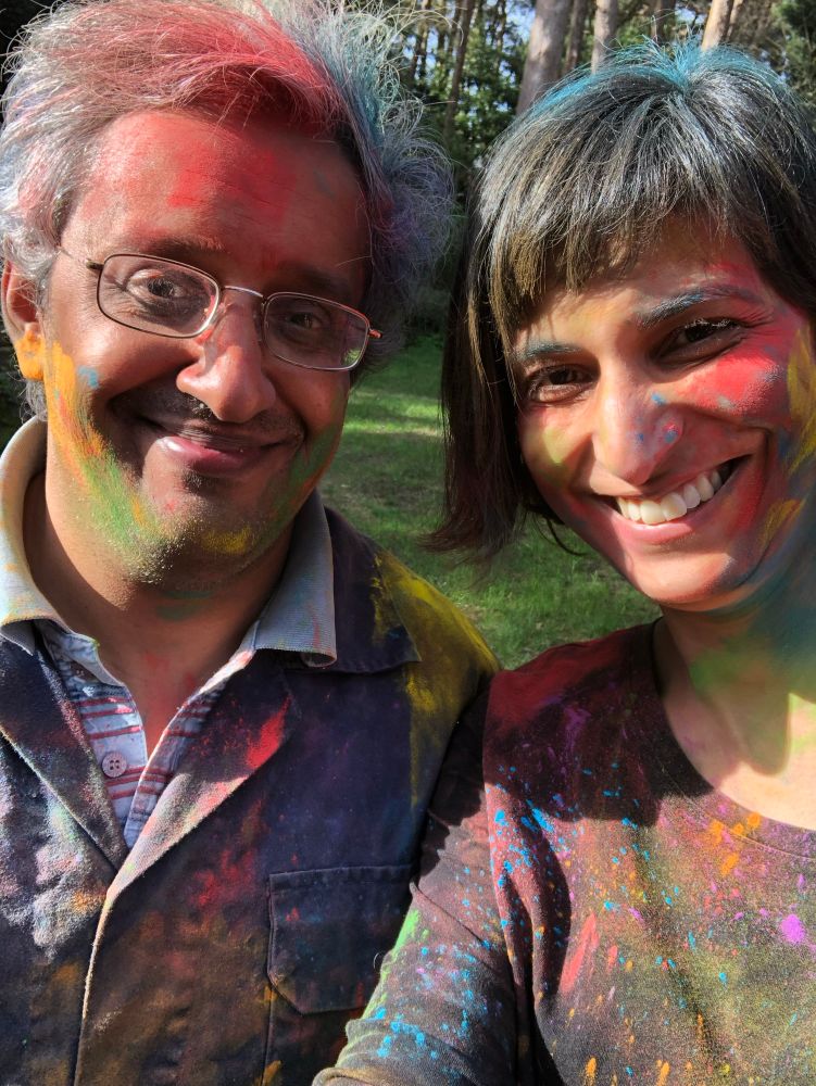 Picture of Sangeet and Devi smiling together and covered with colours for the Hindu festival of Holi
