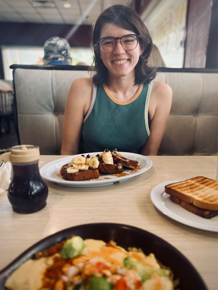 A woman smiling with a plate of food