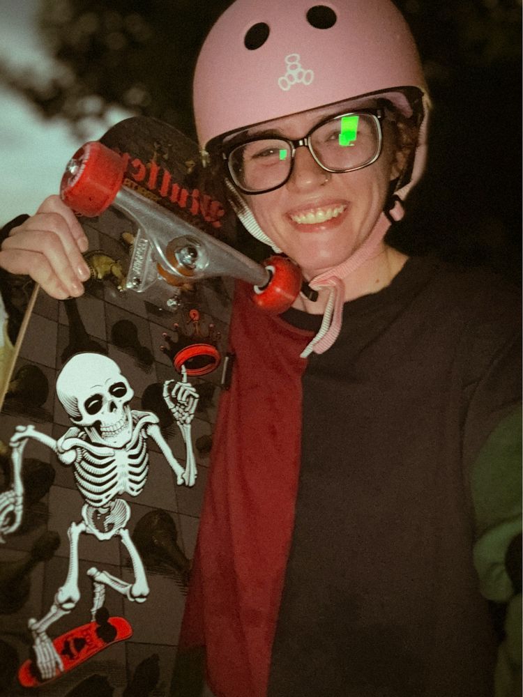 A person wearing a helmet holding a skateboard 