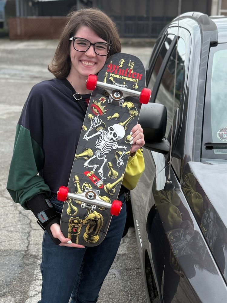 A woman holding a skateboard 