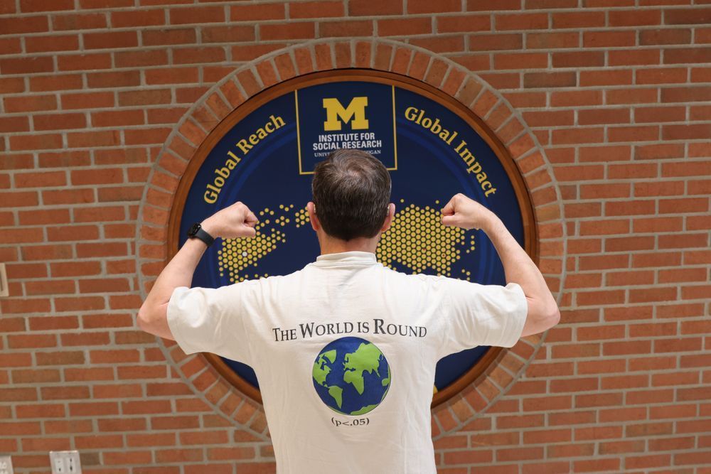 A man with his back turned, flexing in front of a map