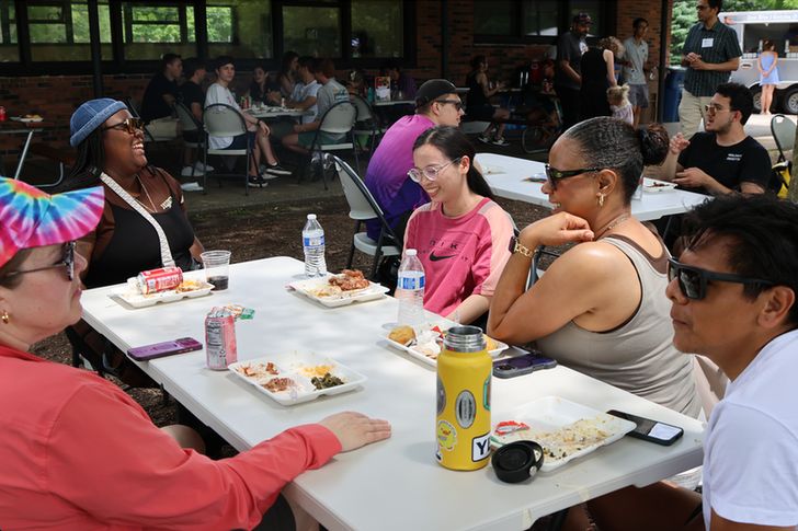 People talking at table with food.