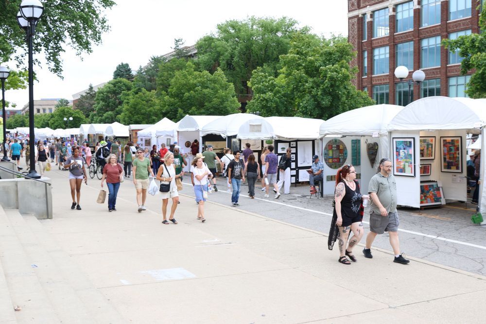 Art fair booths with peoples walking down the street.