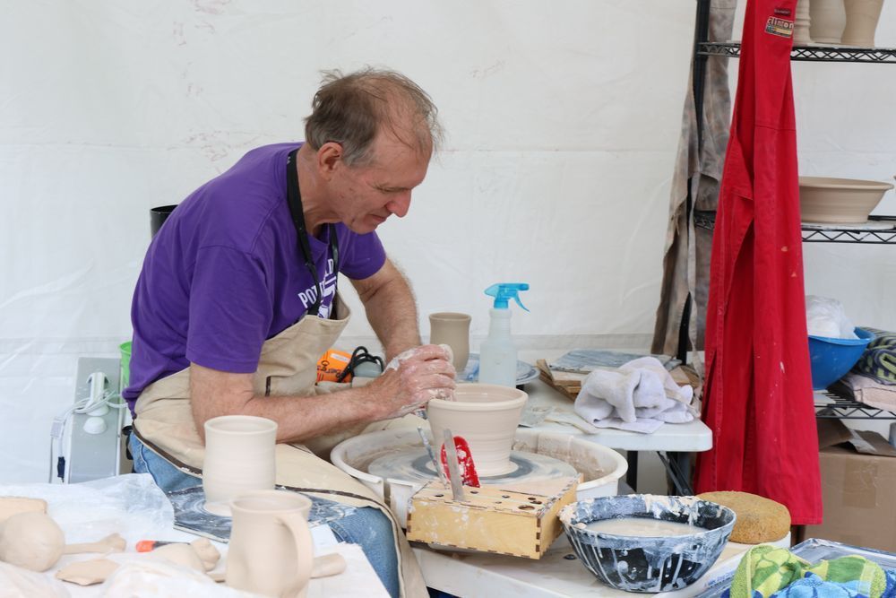 A man throwing pottery on a potter's wheel.