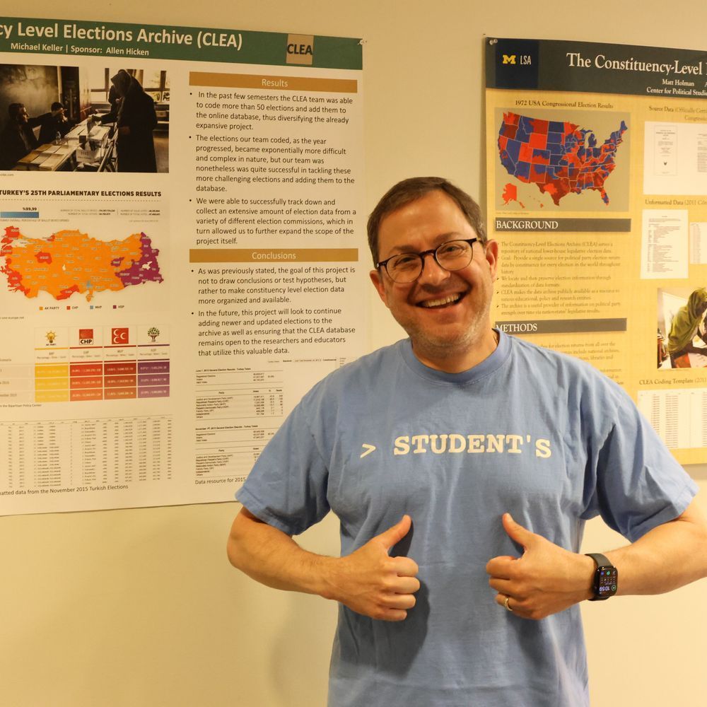 A man smiling while pointing at his shirt