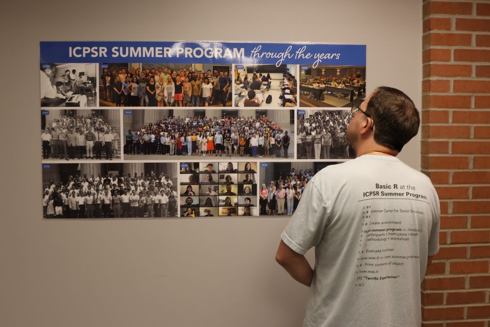 A man looks longingly at pictures of past Summer Programs