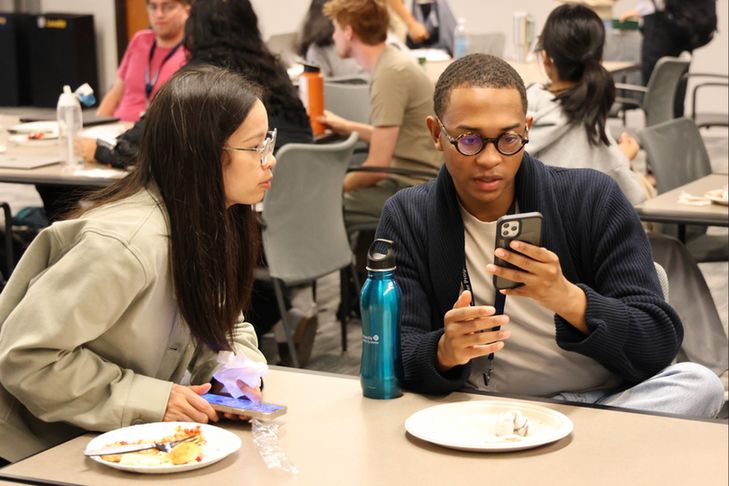 Participant showing phone to another.