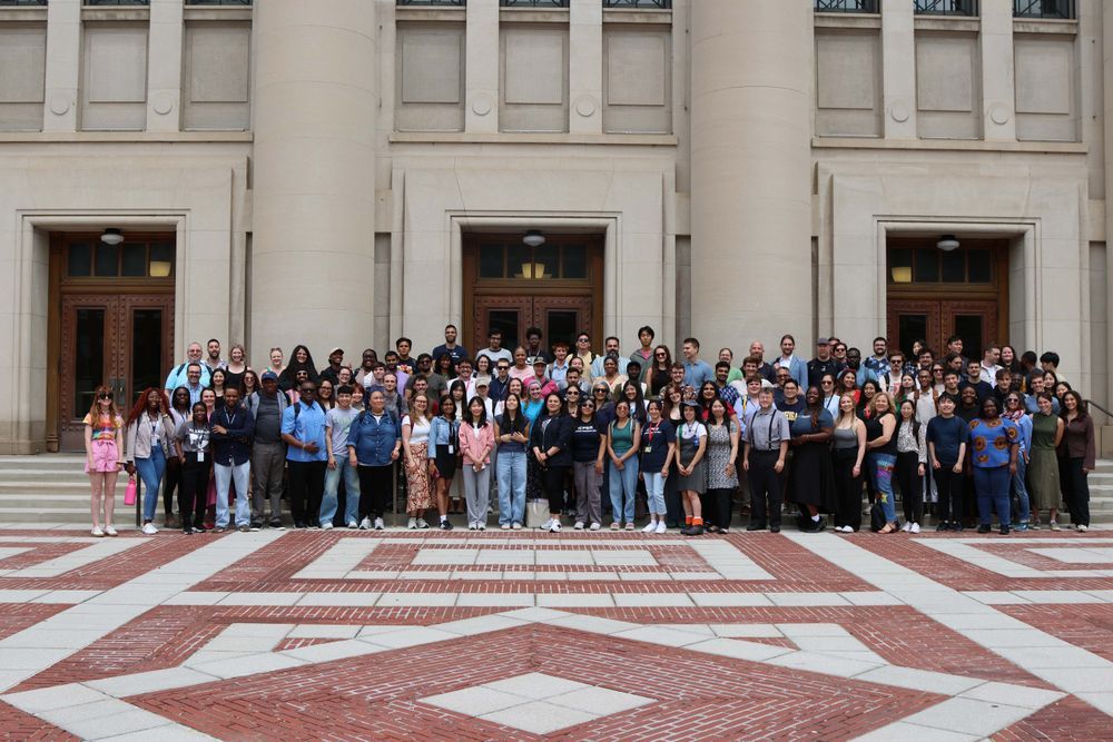 Group of program participants gathered together on the stairs of a building entrance