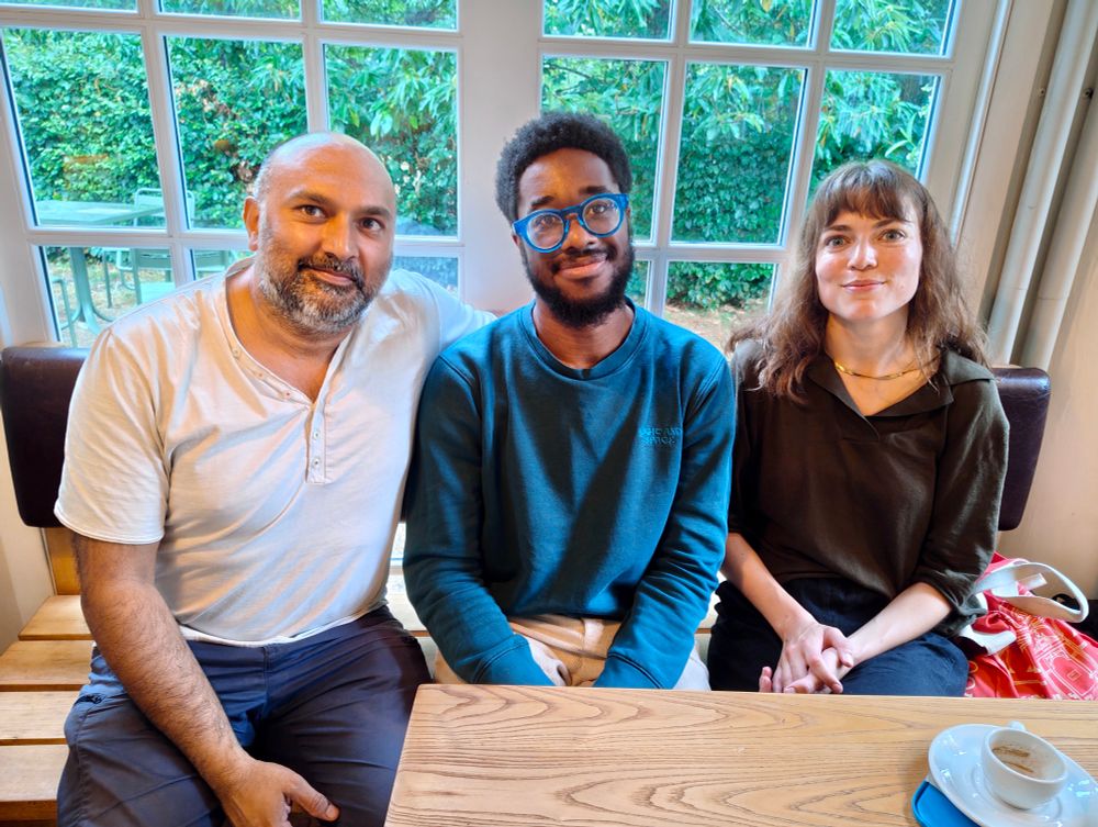3 people sat smiling to camera
