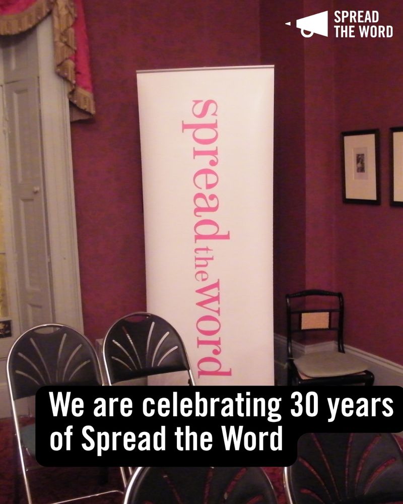 2. An old picture of a room with Spread the Word's old event banner - white with pink lettering 
