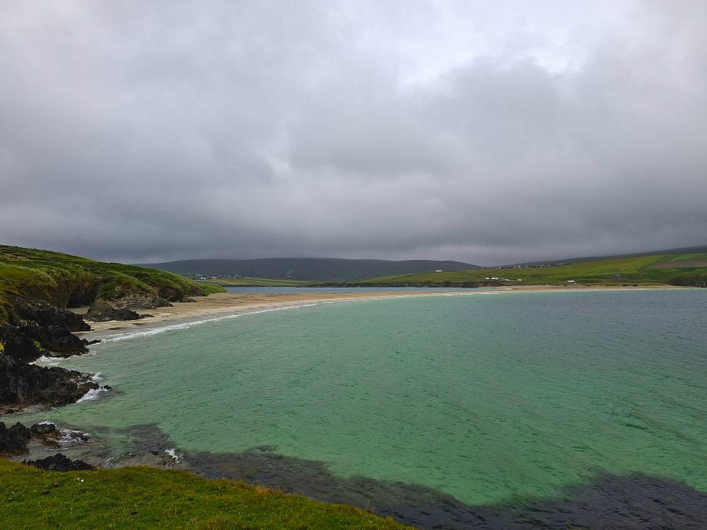 Green blue sea with dark clouds behind 