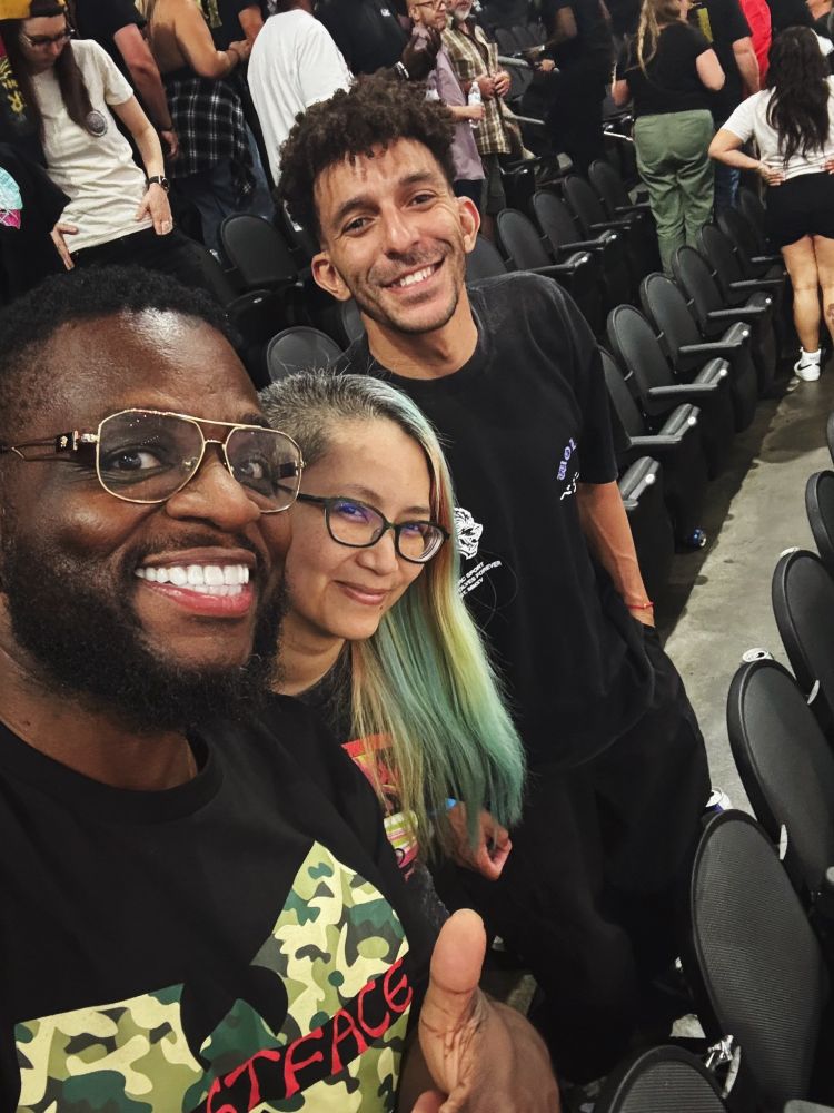 A selfie of Mega Ran, Sarah Dope, and Khleo Thomas in the middle of arena seats at a show.