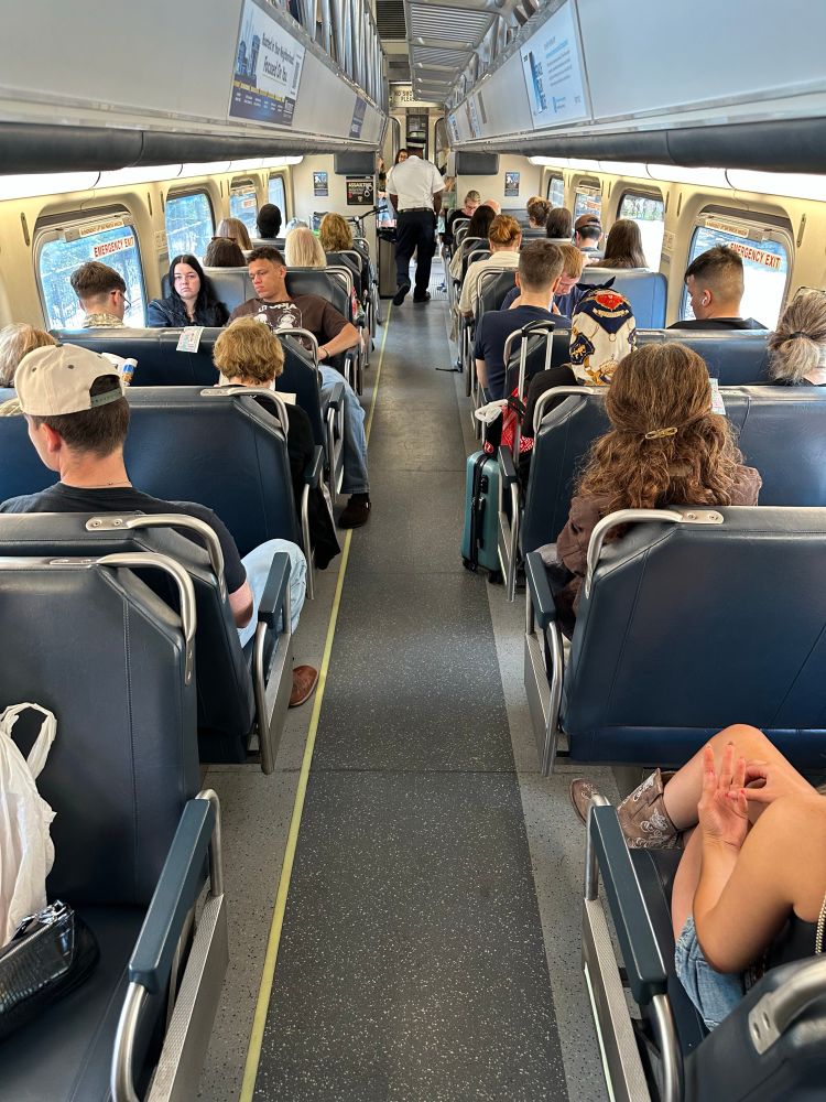 Inside of a Metra train with most seats filled 