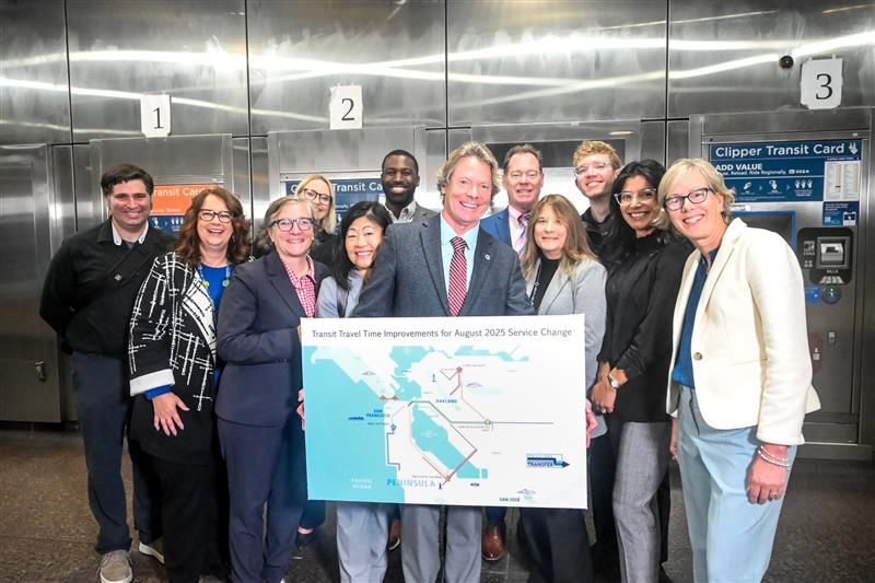 Transit leaders smile with General Manager Bob Powers and a map of the service changes 