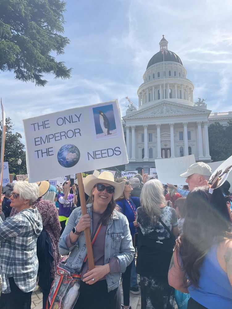 Protestors holding signs in front of the California capitol