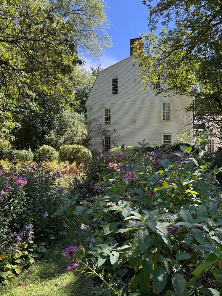 A large white house with an elaborate garden.
