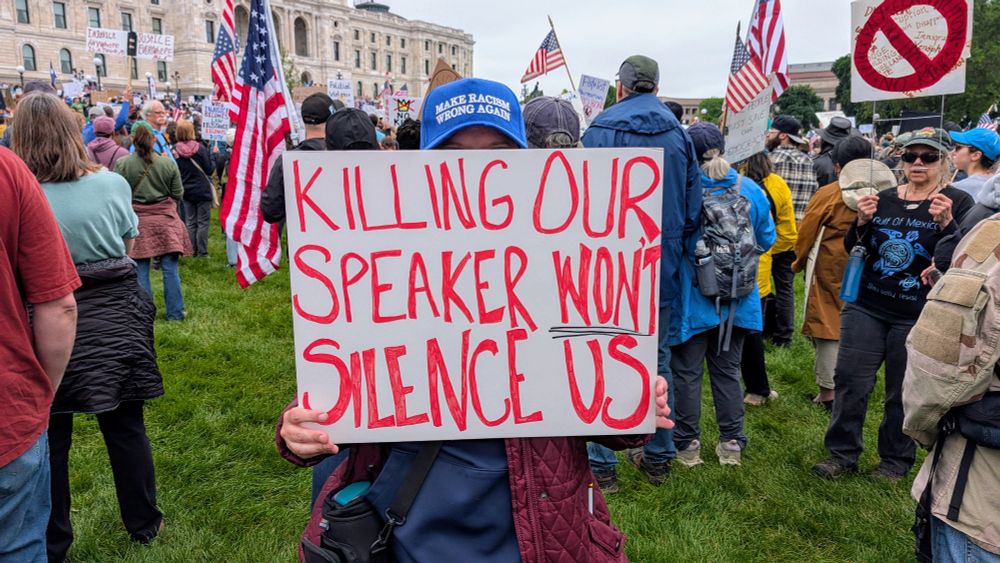 Holding a sign in front of the Capitol "Killing our speaker won't silence us."