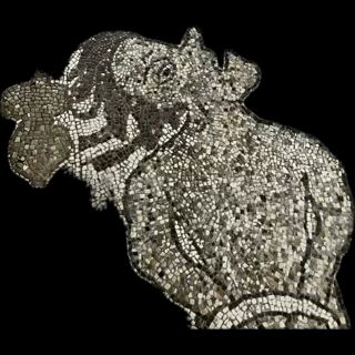 Image of suffering person in hell from mosaic floor of 11th century Cathedral of Otranto, Salento Italy. Black gray and white tesserai form a person with hands bound behind back, mouth open in pain or shout and hair moving or blowing in breeze. Image because the Cathedral is another place with a chapel containing many bones.