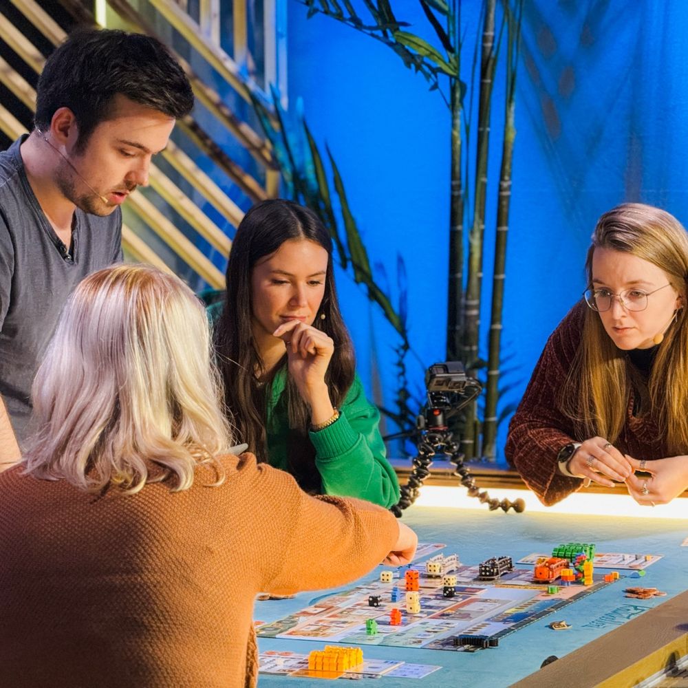 Fünf Personen spielen Brettspiele auf einem Tisch