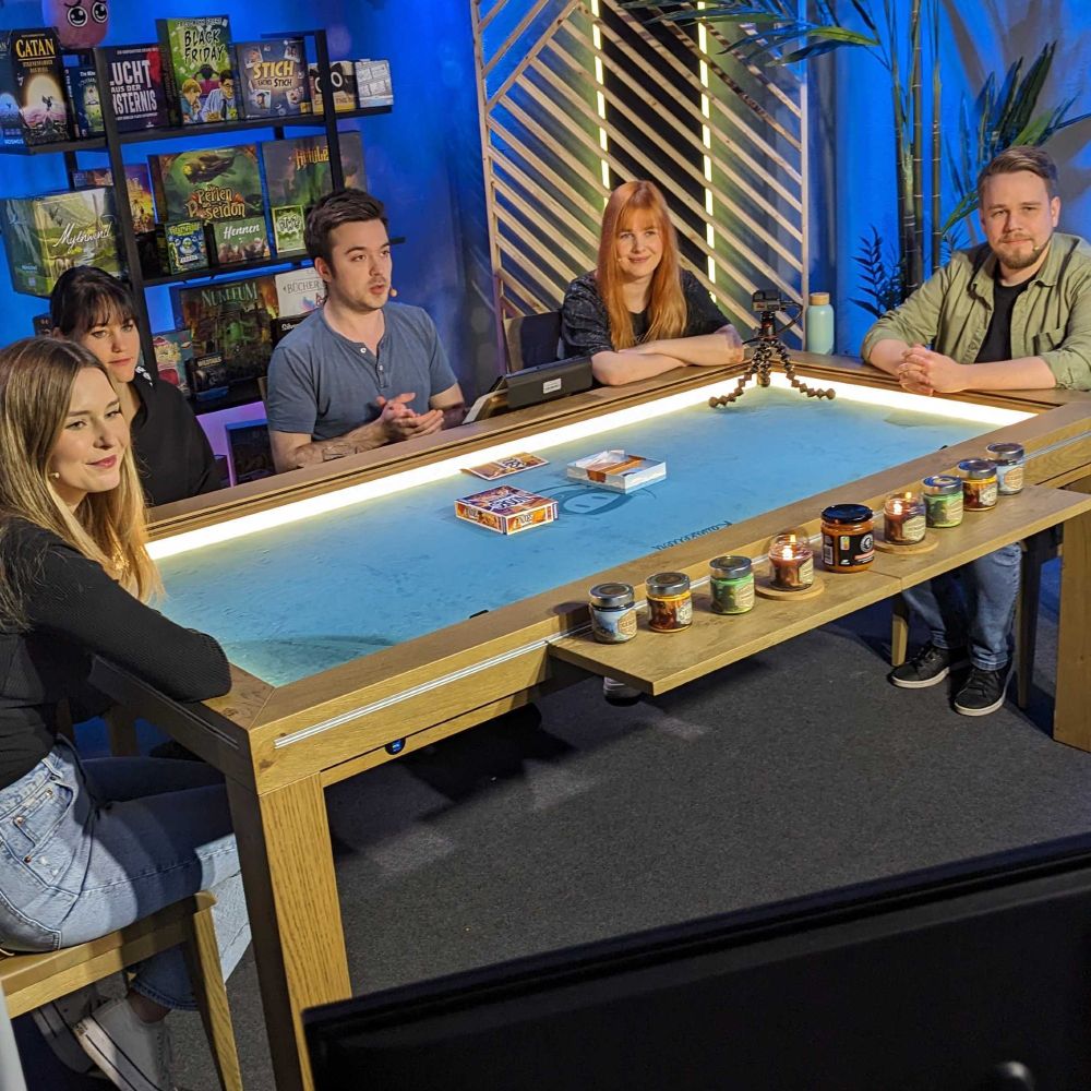 Fünf Menschen an einem Brettspieltisch