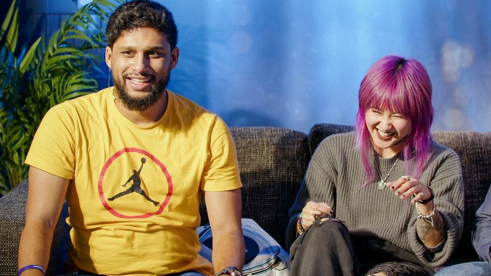 Zwei Menschen lachend auf der Couch.
