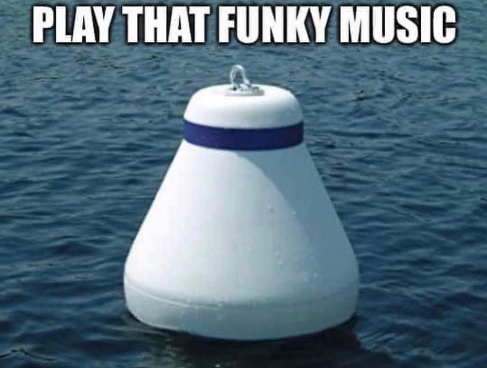 The image features a large, white, conical buoy floating on a body of water. The buoy has a smooth, rounded top with a blue band around its middle, and a metal ring at the top for securing it. The water surrounding the buoy is calm, with gentle ripples visible. The buoy is centered in the image, with the text "PLAY THAT FUNKY MUSIC" prominently displayed at the top in bold, white capital letters. The buoy's shape and the text create a humorous juxtaposition, as the buoy is typically used for navigation and safety at sea, while the text references a popular song.