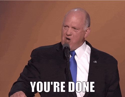 a man in a suit and tie is giving a speech and says you 're done