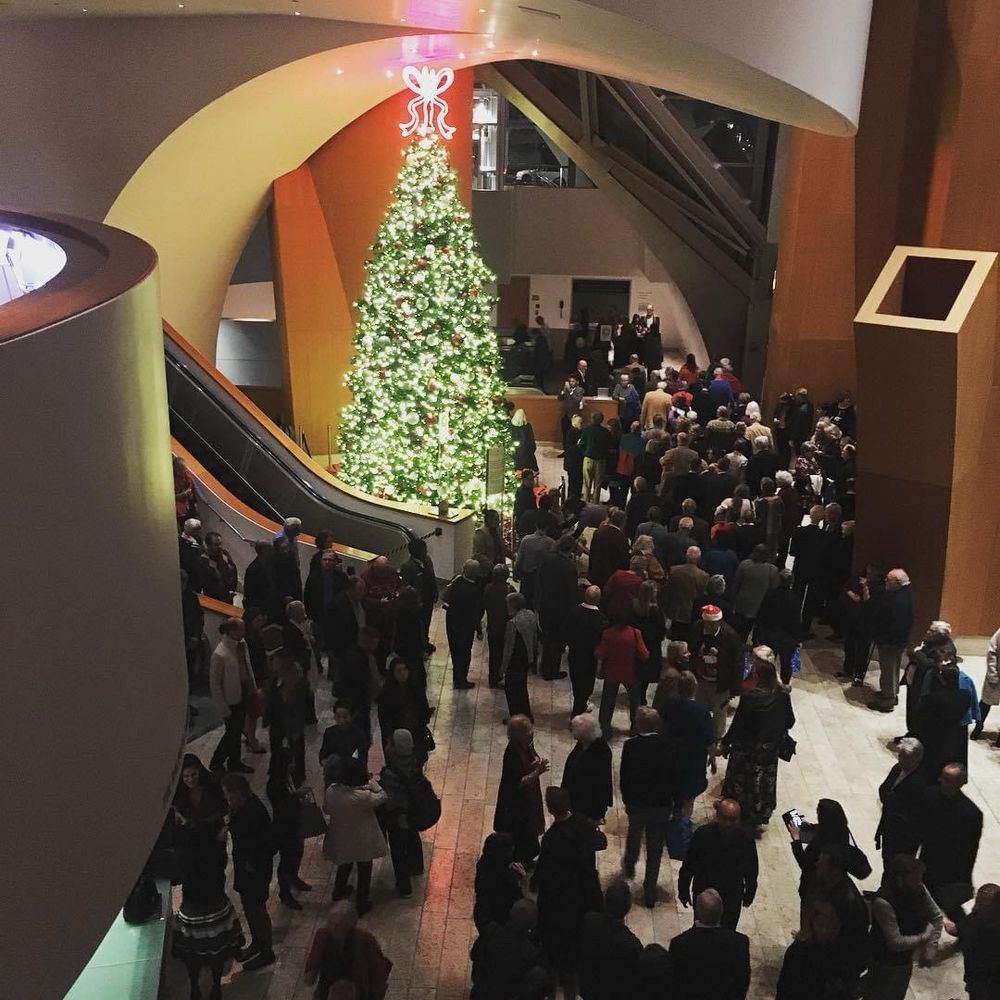 Lobby of Walt Disney Concert Hall with lots of patrons and a beautiful Christmas tree.