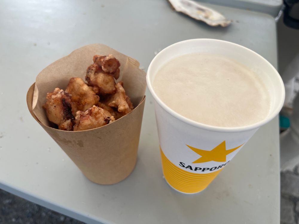 たこザンギとサッポロビール。飲食可能ブースがすごいことになっており牡蠣の殻まで転がってる始末。