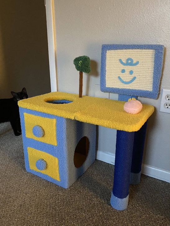 A colourful cat tree shaped like a computer and desk.