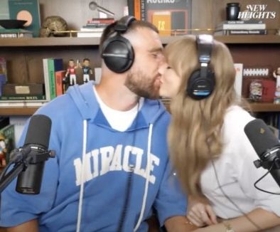 Travis Kelce and Taylor Swift kissing on the New Heights podcast