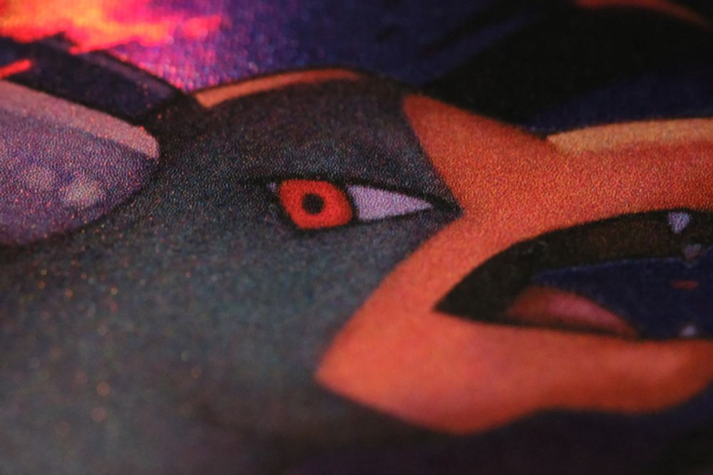 The same image, but magnified even further on the head.  The holographic speckles are easier to see, with many of them interspersed even throughout Houndoom's body.  The holographic speckles look like tiny flecks of red-orange, fiery ember, making for a really neat visual effect.