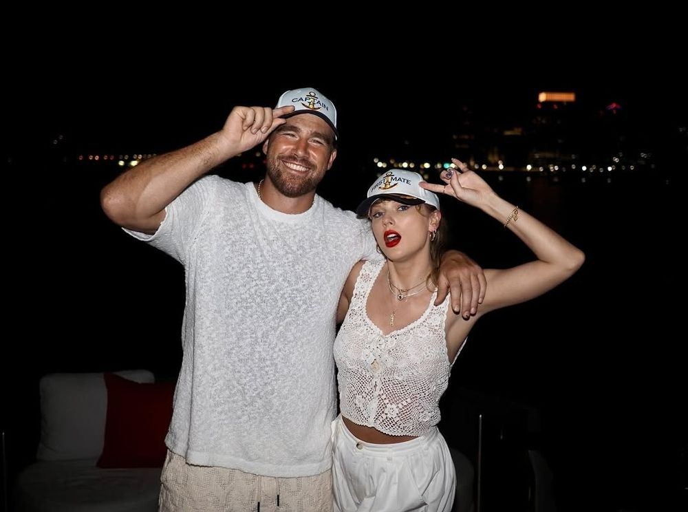 Travis kelce and Taylor swift both in full white outfits and matching caps that say "captain"