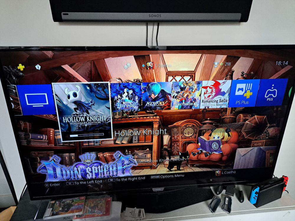 A PlayStation 4 home screen downloading Hollow Knight