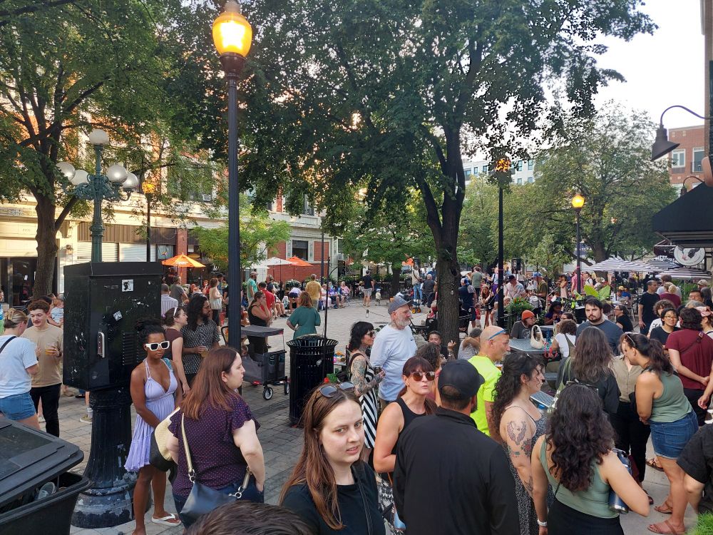 Crowd of people enjoying sun and music in Lincoln Square Chicago