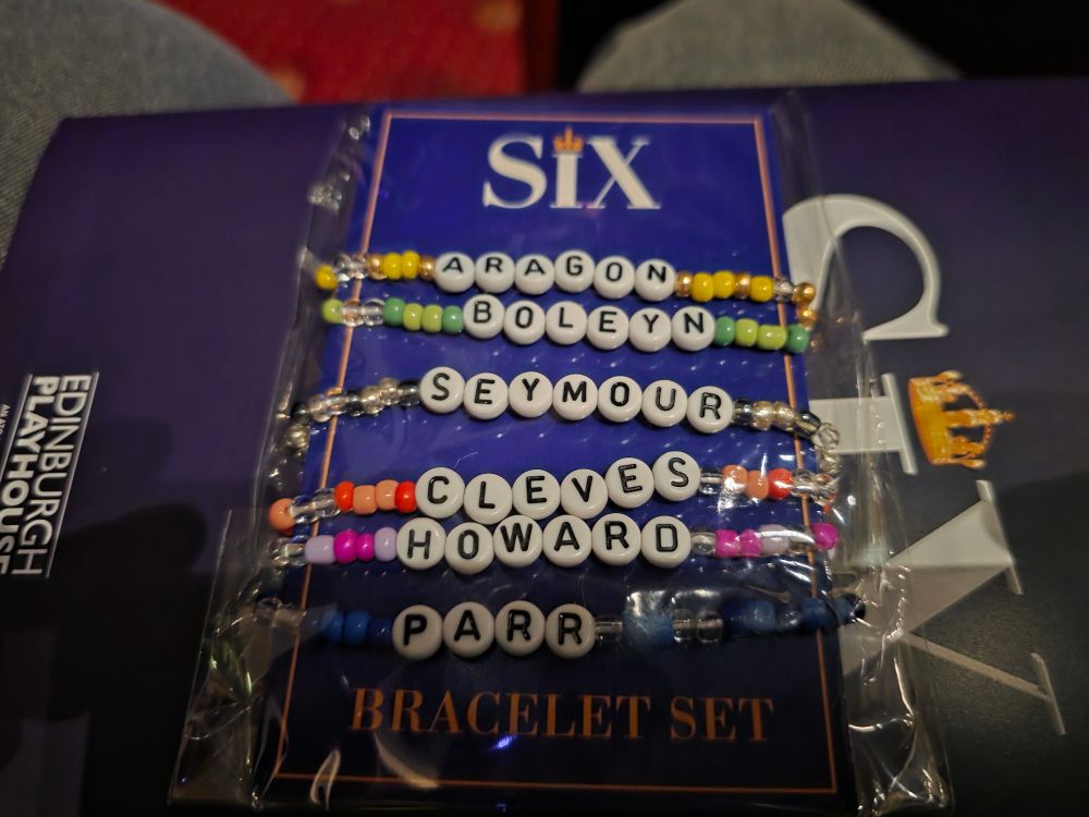 Merchandise for the musical Six, the picture shows friendship bracelets for each of the six wives.