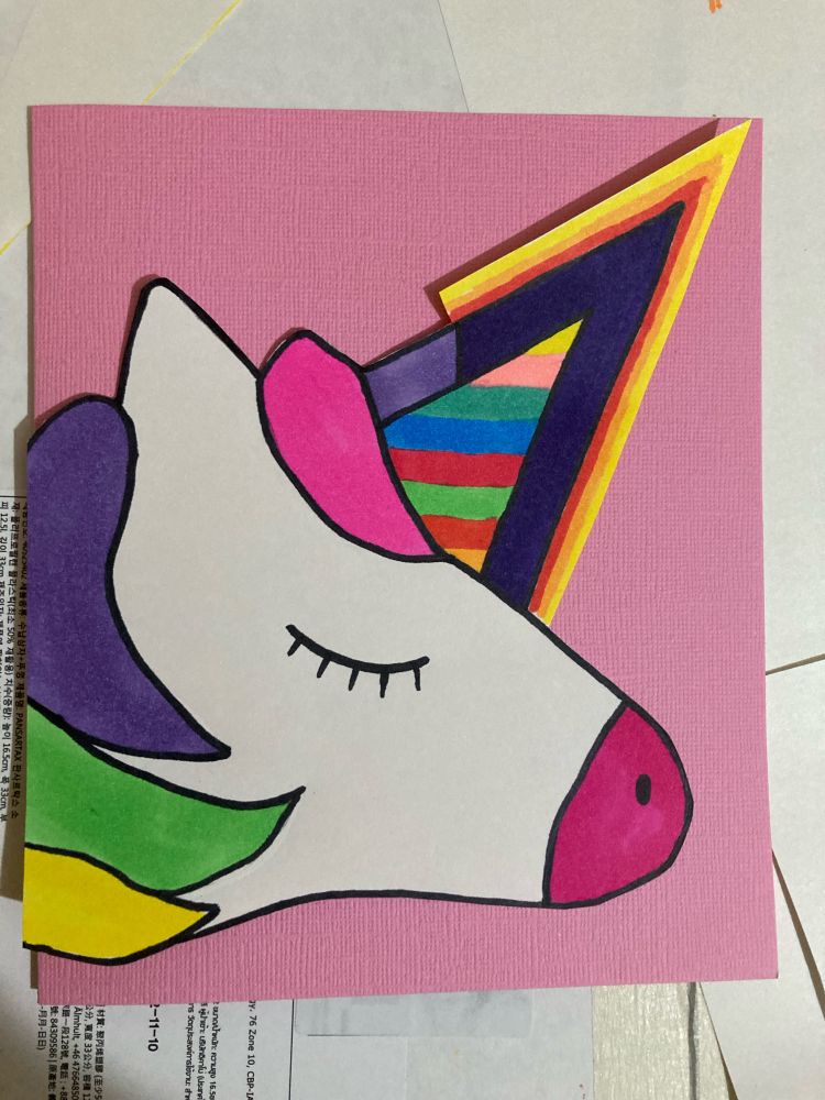 Pink card with a unicorn head with the horn in the shape of a number seven 