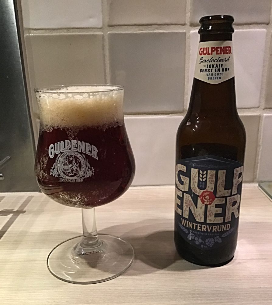 Gulpener Wintervrund (donker winterbier) in glas met daarnaast de bierfles. 